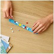 Lifestyle view highlighting the manual building and assembly process of the LEGO DOTS 41900 Rainbow Bracelet SOLD OUT model. 