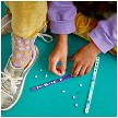 Lifestyle view highlighting the manual building and assembly process of the LEGO® DOTS 41909 Mermaid Vibes Bracelets model. 
