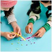 Lifestyle view highlighting the manual building and assembly process of the LEGO® DOTS 41910 Ice Cream Besties Bracelets model. 